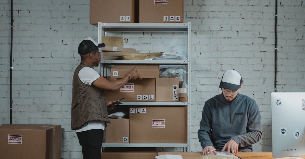 Two male workers organizing and packing boxes in a warehouse setting.